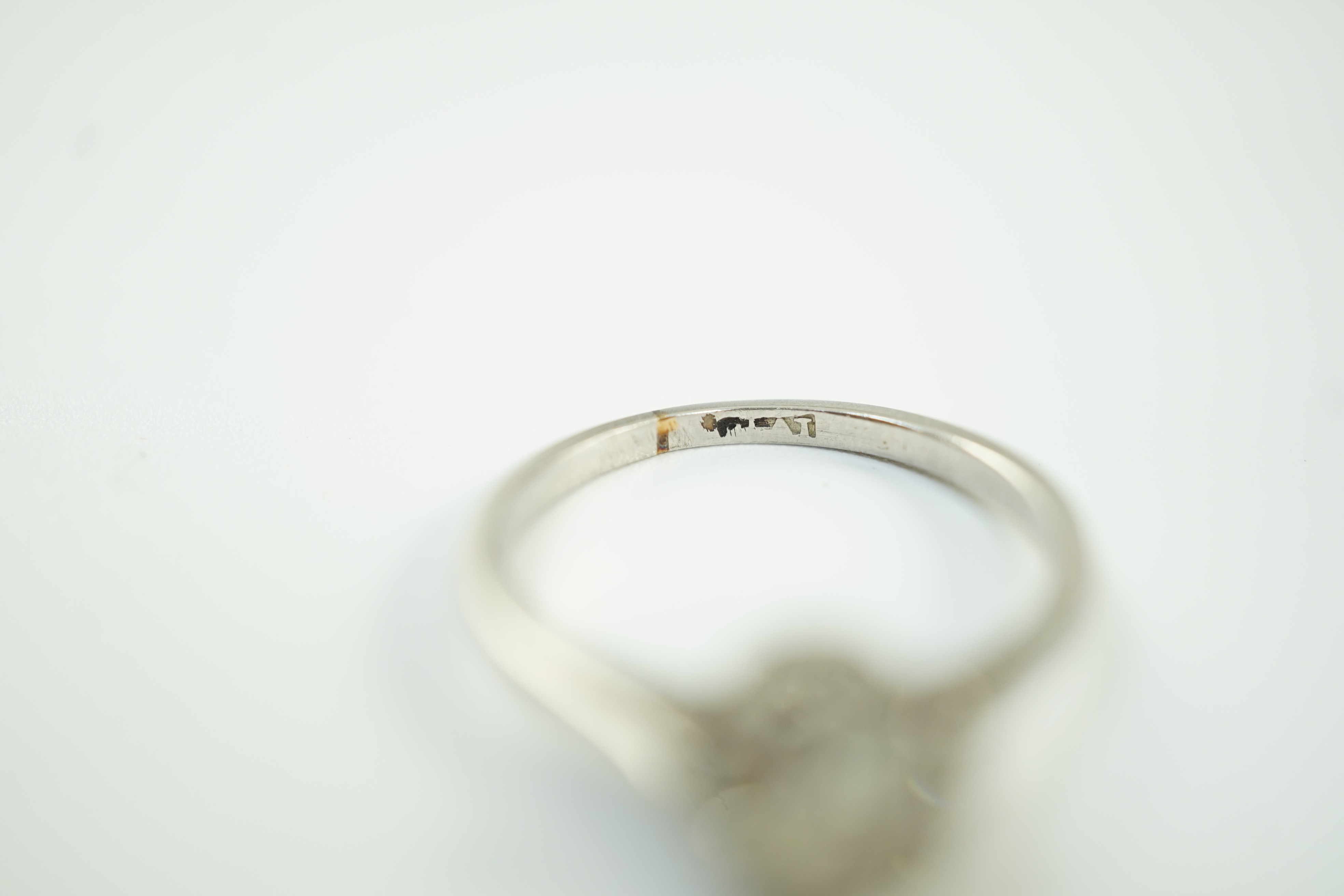 A white metal (stamped plat) and solitaire diamond ring, size J, gross weight 2.6 grams